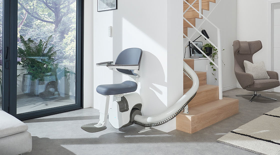 Access BDD Flow X Stair lift at the bottom of a curved staircase.
